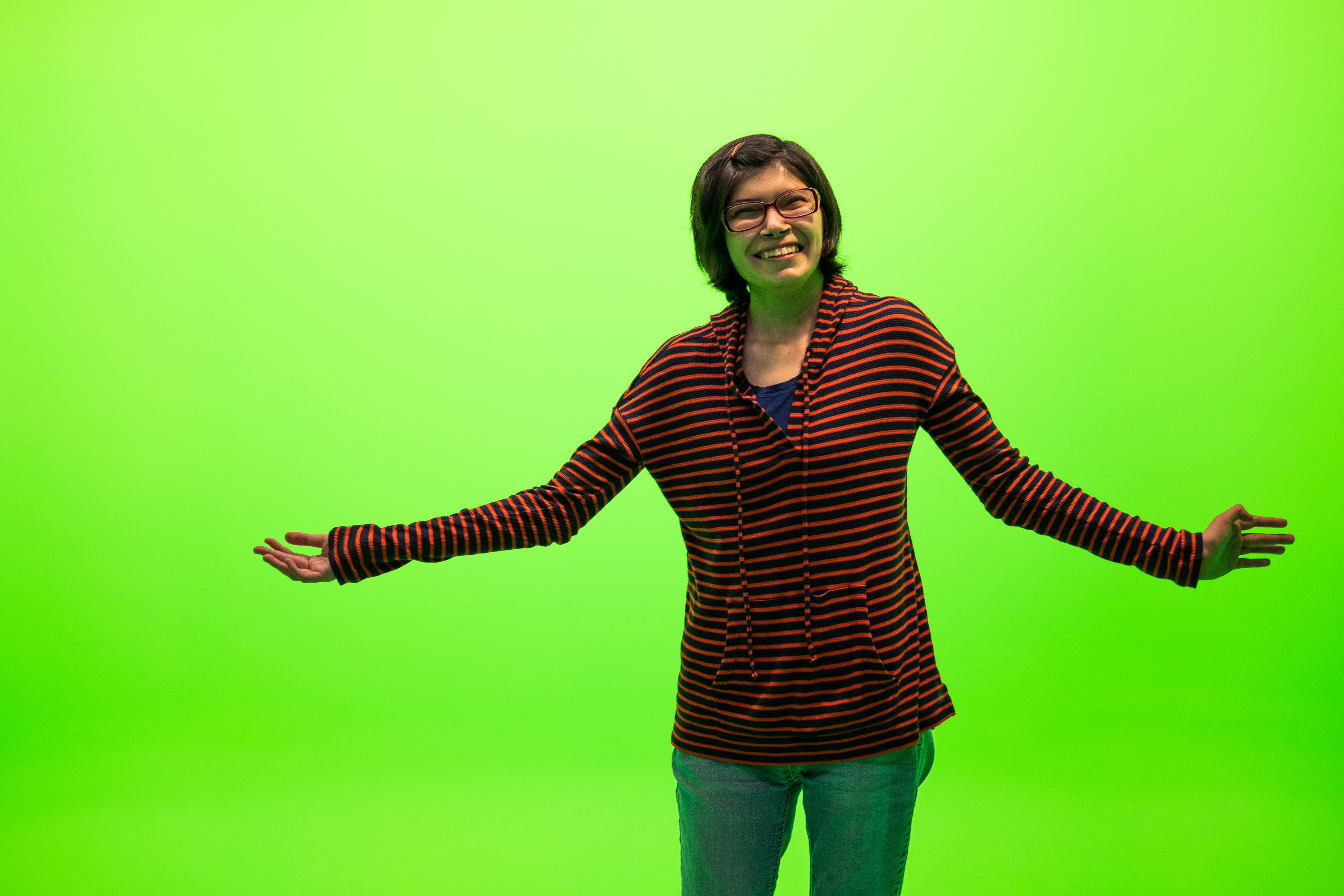 female student in front of green screen