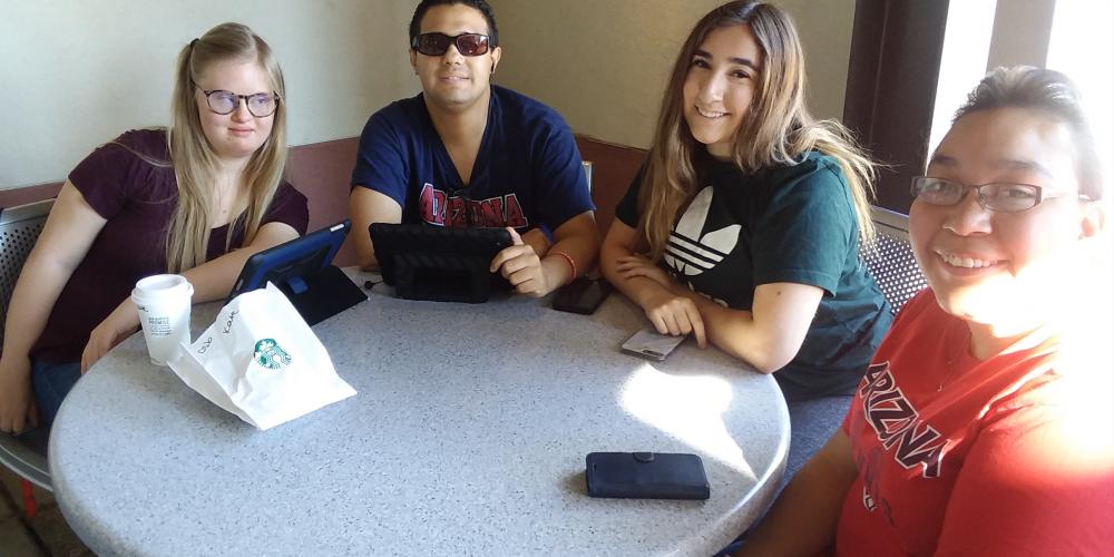 group of four students sitting at table