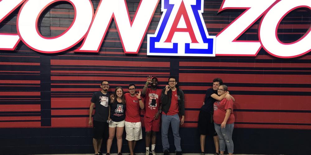 group of students standing in front of ZonaZoo sign
