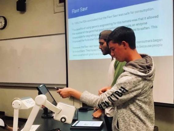 two male students presenting in front of class
