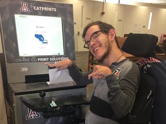 male student using printing kiosk on campus