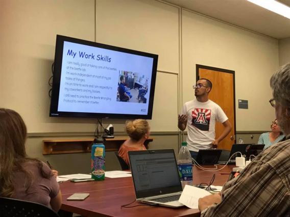 male student standing in front of IEP attendees presenting