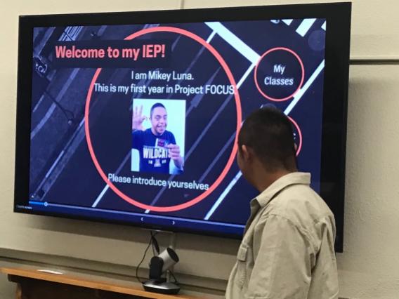 male student reading first slide of presentation