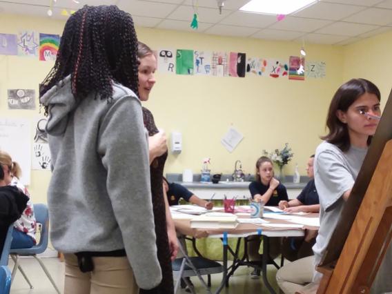 female student teaching art to middle schoolers
