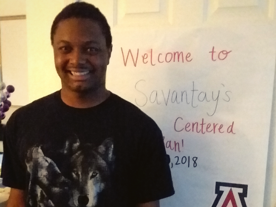 male student standing and smiling in front of his PCP poster