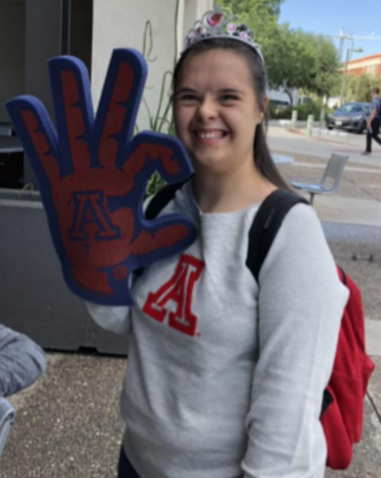 student smiling and holding up a Wildcat foam hand
